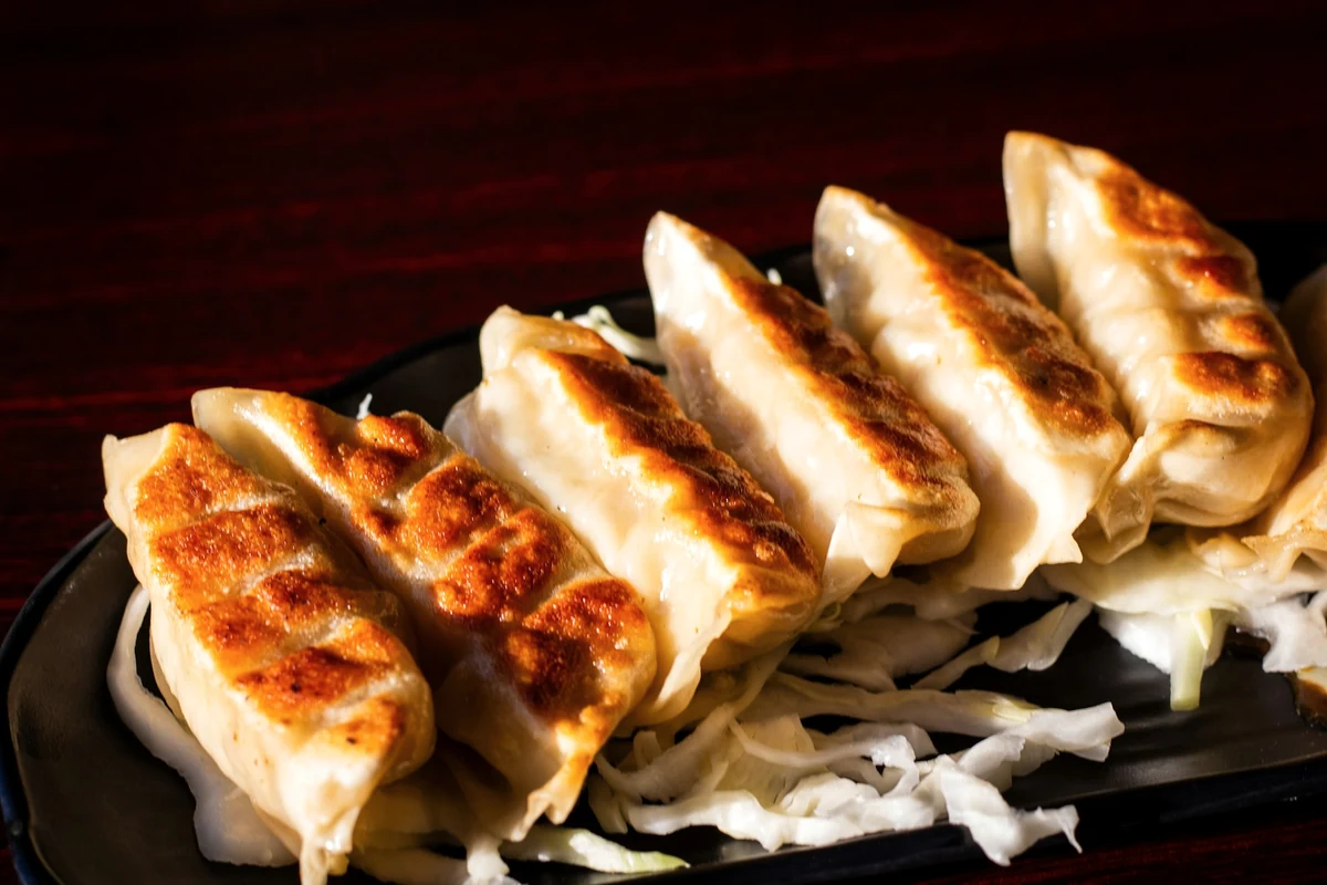 Golden pan-fried gyoza on a black plate